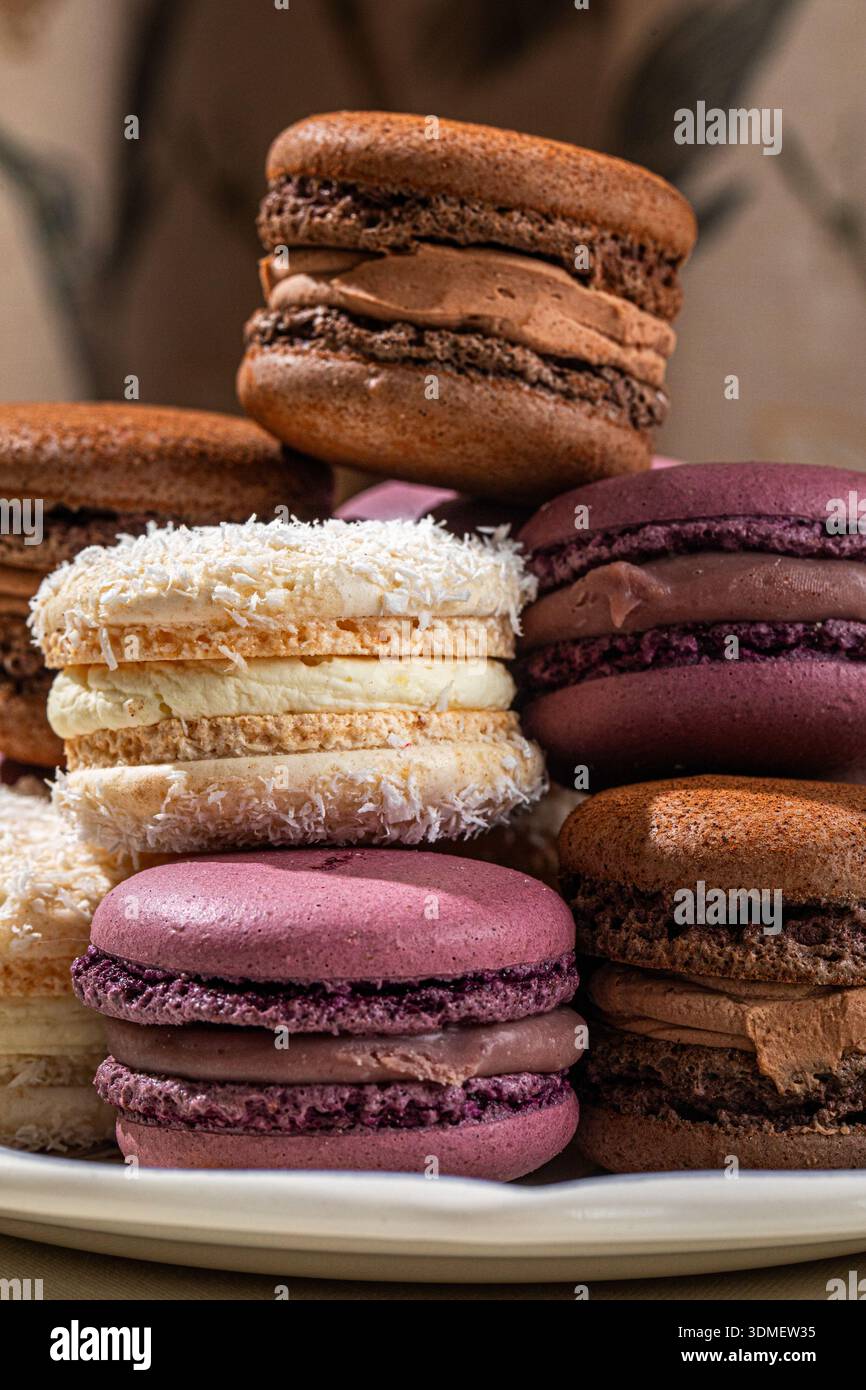Assorted macarons stacked on decorative plate Stock Photo