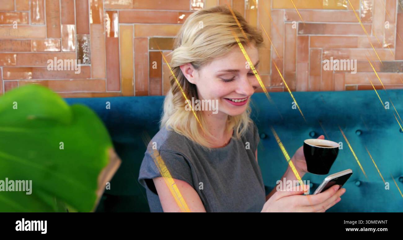 Smiling lady in grey dress checking phone at cafe holding black cup teal-bench plant-leaf wood-wall Stock Photo