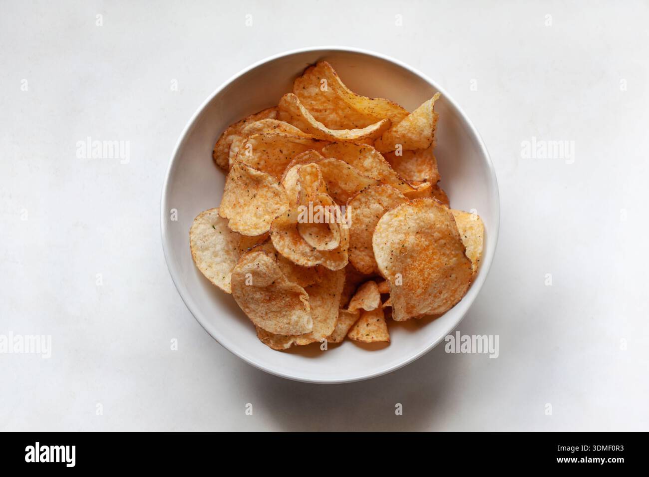 Potato chips in a white bowl Stock Photo