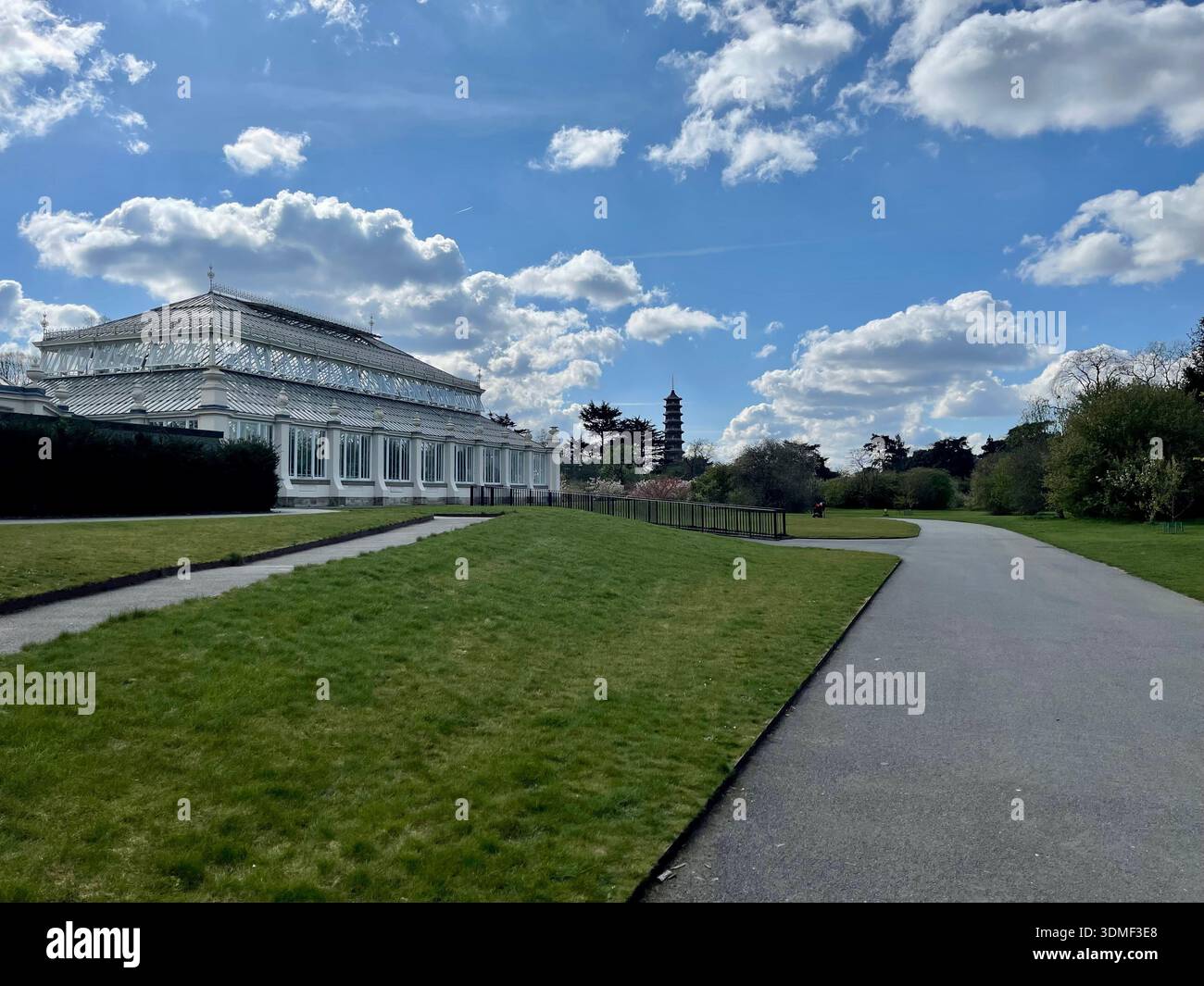 The Temperate House, a Victorian Glass House located in Kew Gardens, London with the Great Pagoda in the distance. - Smartphone Captured Stock Image