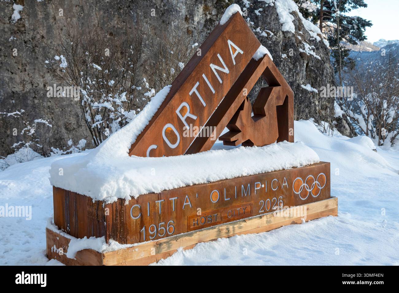Snow-covered sign marking Cortina d'Ampezzo as Olympic host city, with ...