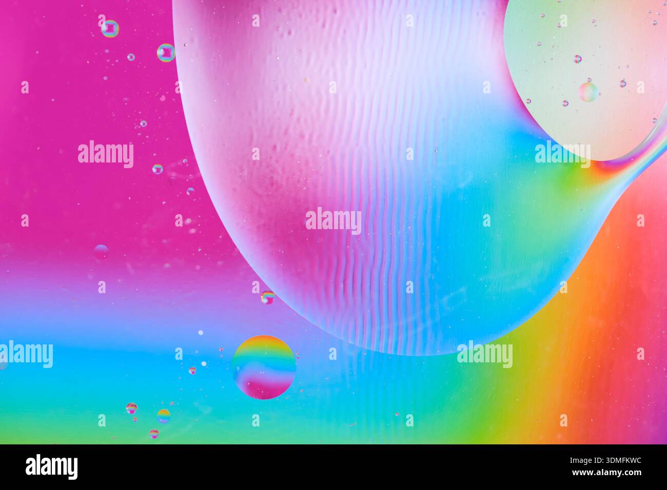 Macro view of large oil sphere on colorful rainbow background with ...