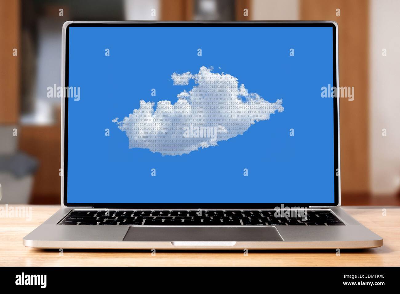Laptop displaying a cumulus cloud with binary data against blue sky Stock Photo
