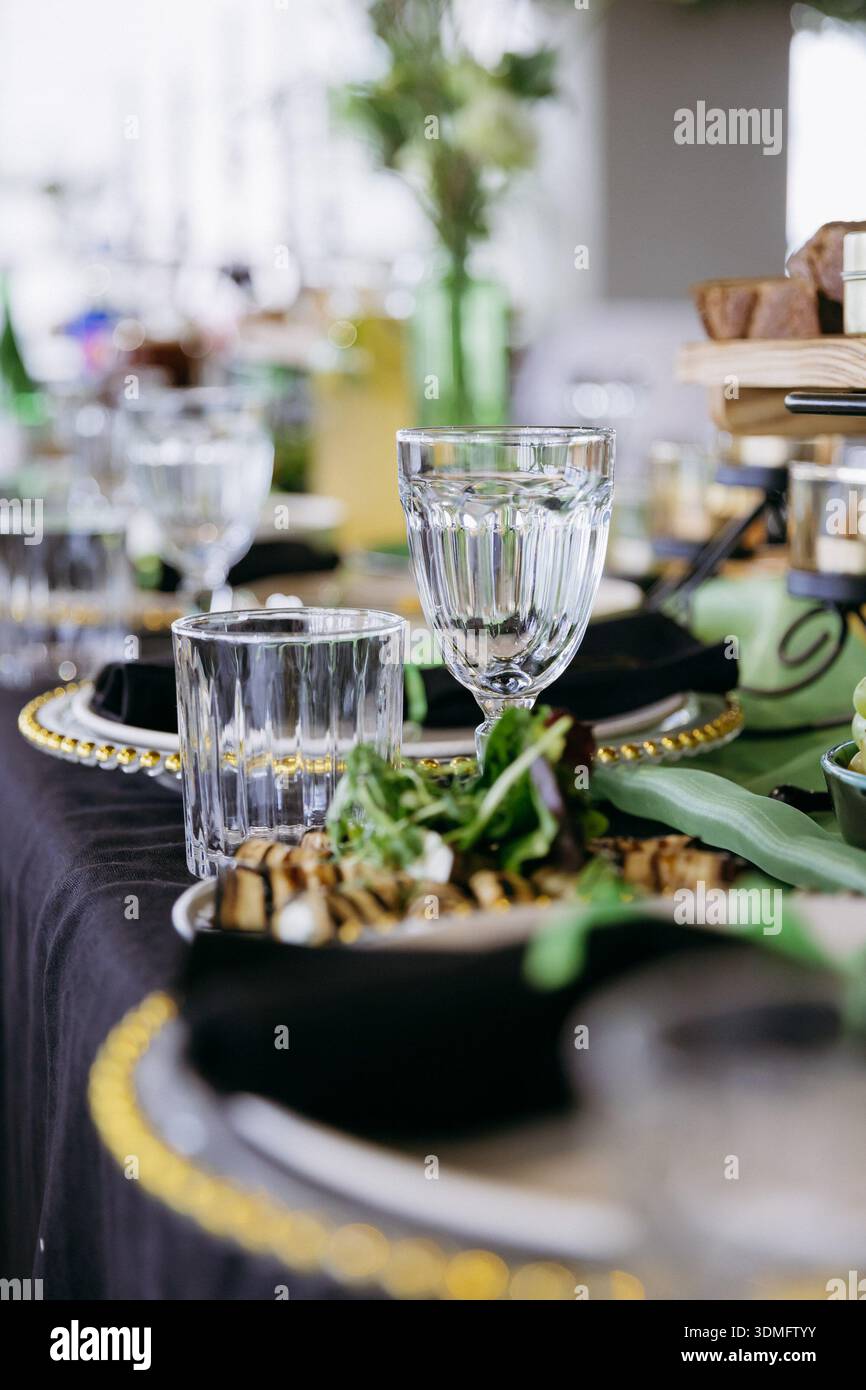Close up of elegant event table setting with glassware and appetizer Stock Photo