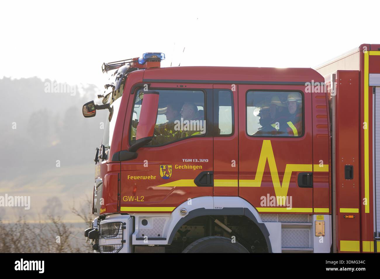 Closer look at a fire engine driving on a street with people inside ...