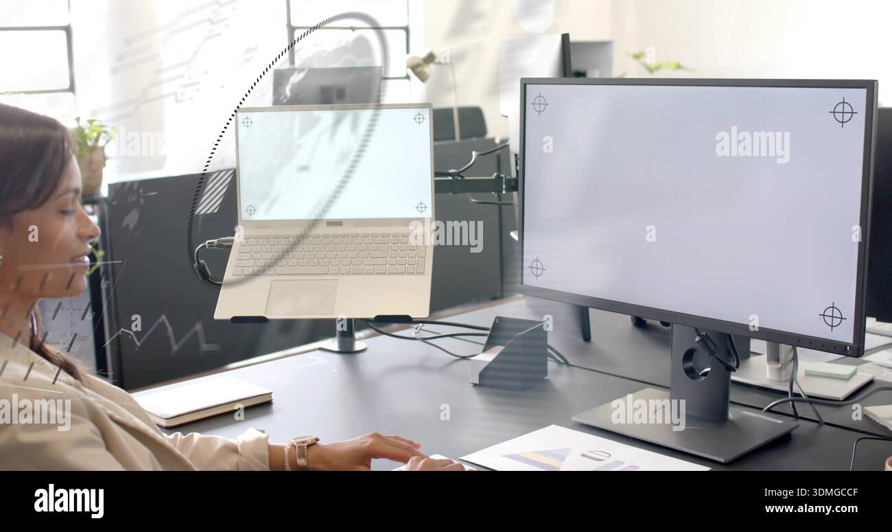 Working woman wearing beige blazer sitting at office desk, with laptop on raised stand, copy space Stock Photo