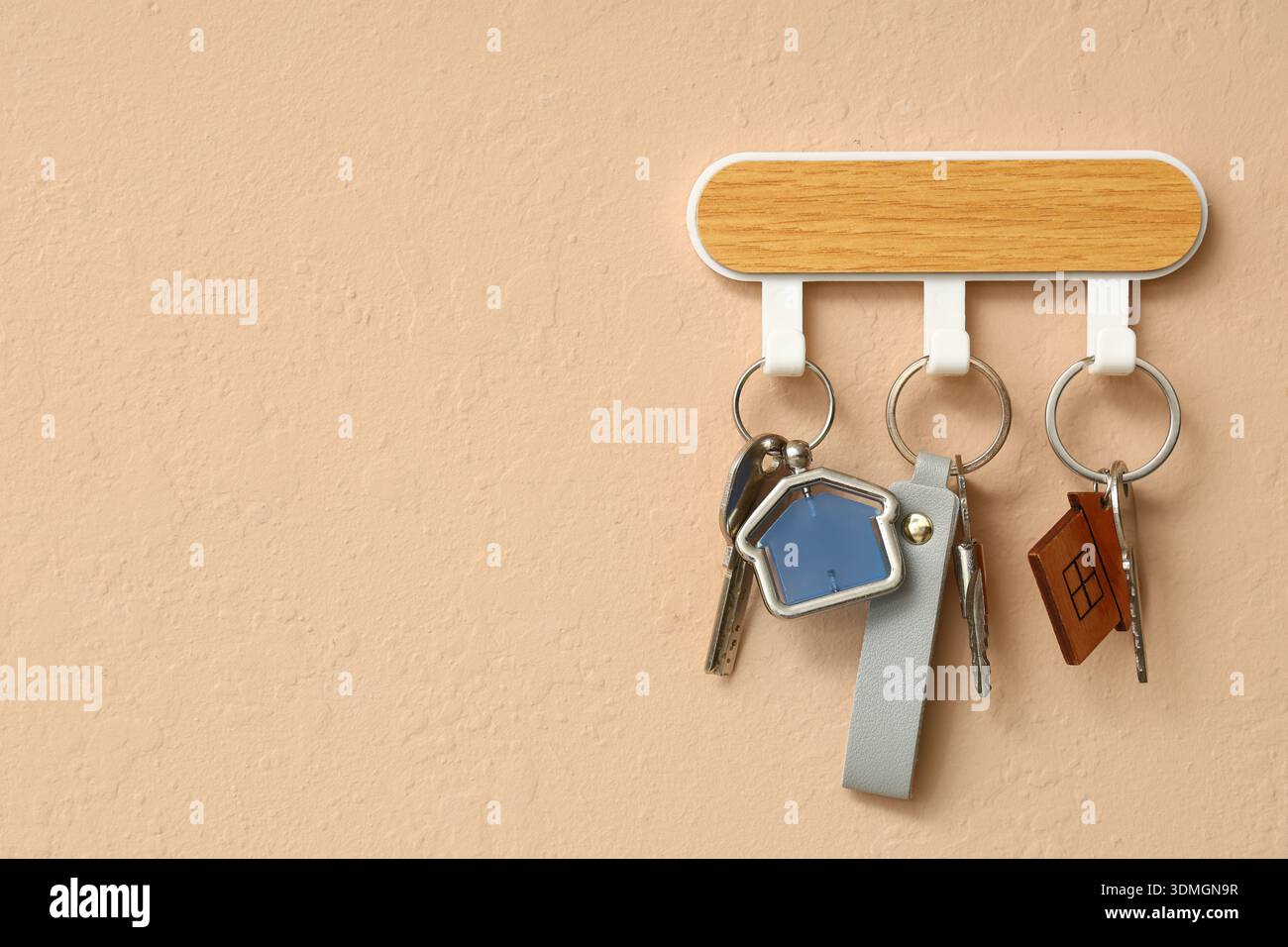 Rack with keys from house on beige wall Stock Photo