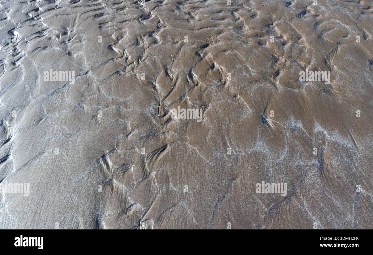 Natural patterns and textures created by water and wind on a sandy beach Stock Photo