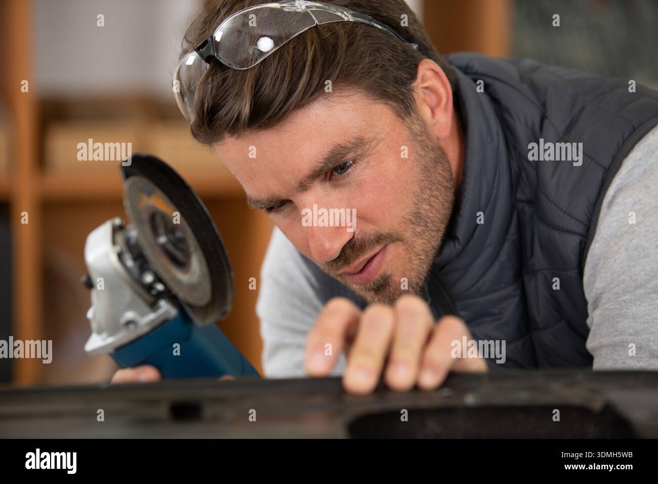 construction worker using handheld circular saw Stock Photo
