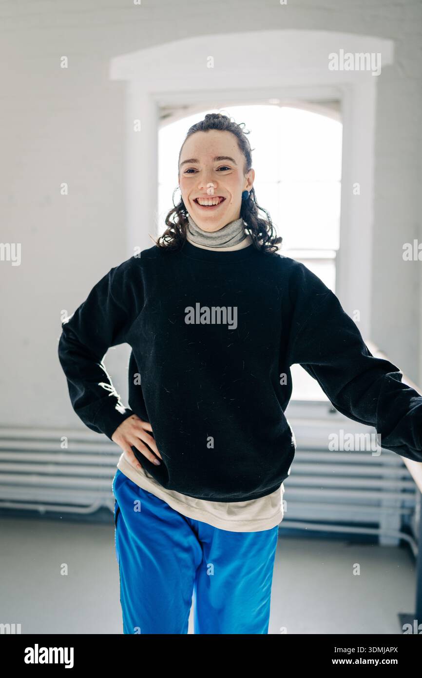 Young woman smiling casually standing in studio Stock Photo
