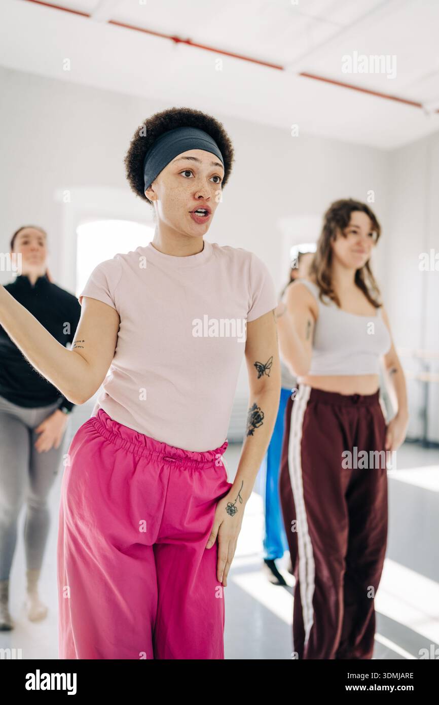 Dance instructor leading exercise class with diverse students Stock Photo