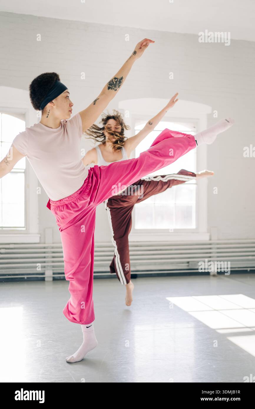 Two dancers practicing contemporary movements in bright studio Stock Photo