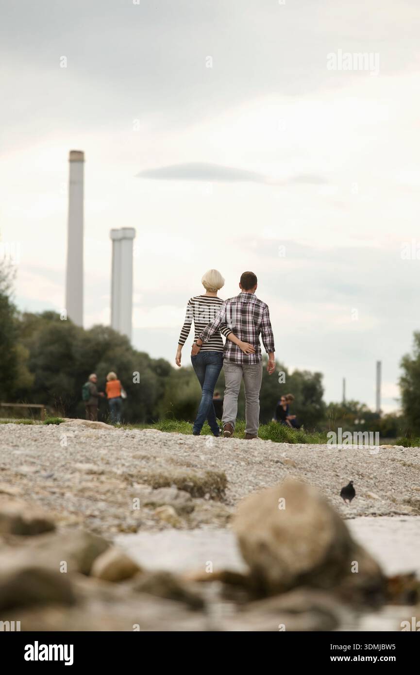 Rocky Riverside Back view of a young couple walking together on a rocky riverside Stock ...