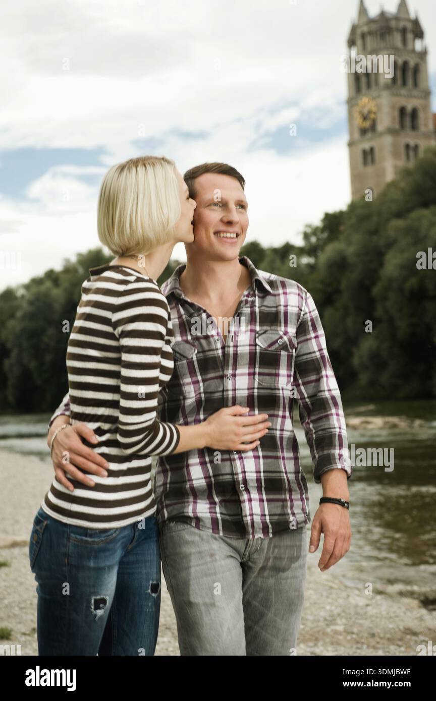 Young couple standing close together on a riverside Stock Photo