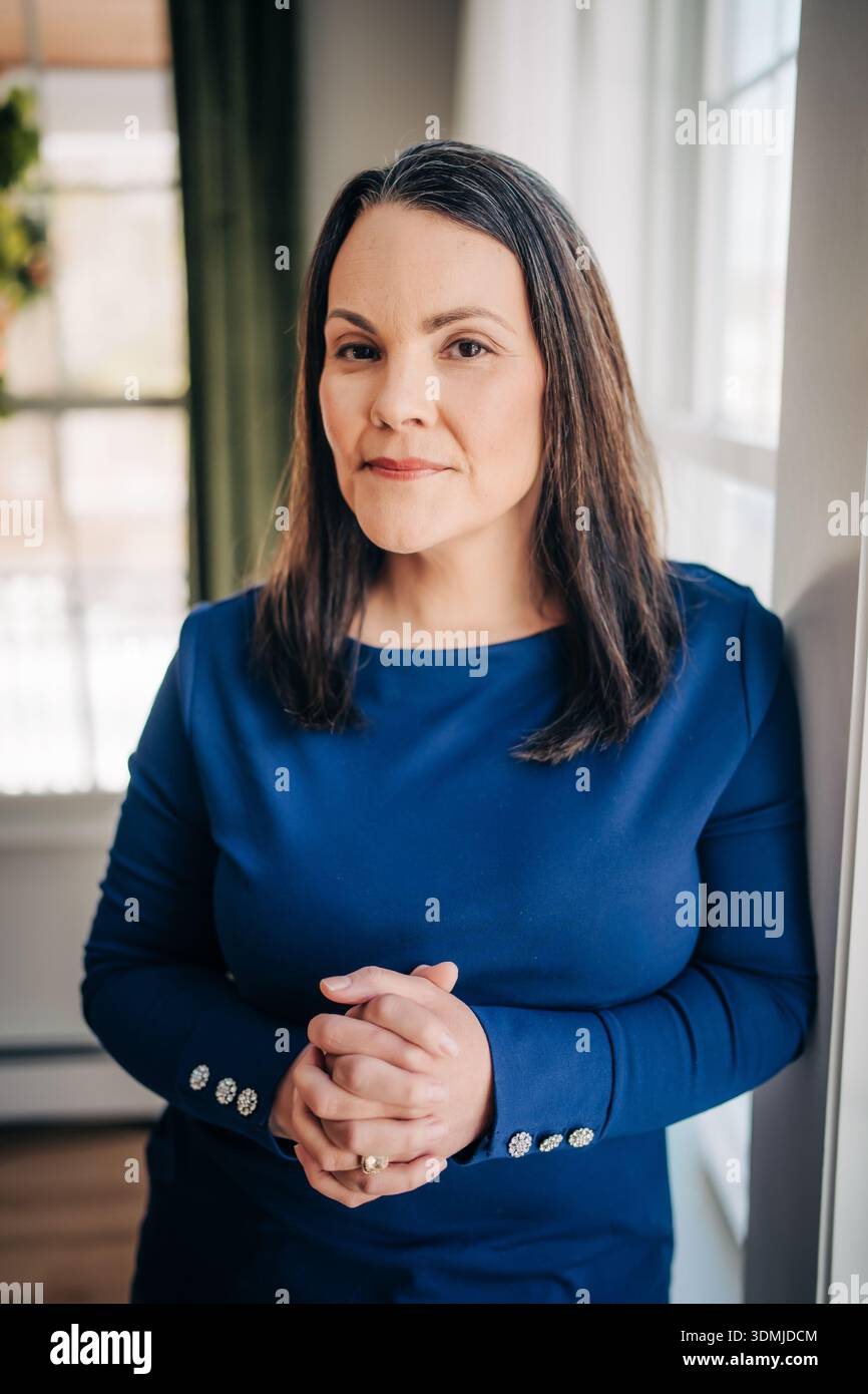 Professional woman standing with hands clasped Stock Photo