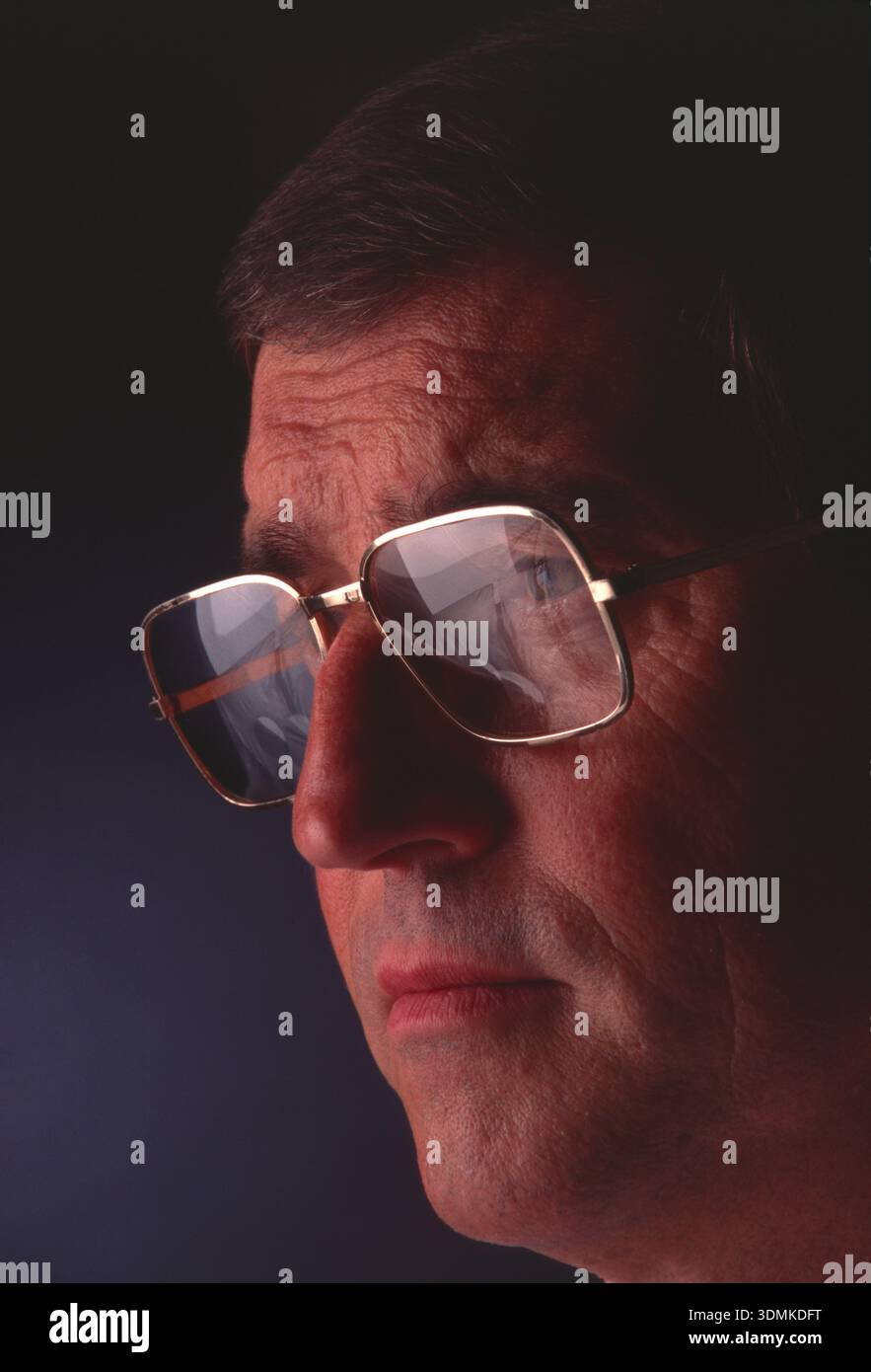 Middle-aged man, wearing spectacles with computer screen reflection. Stock Photo