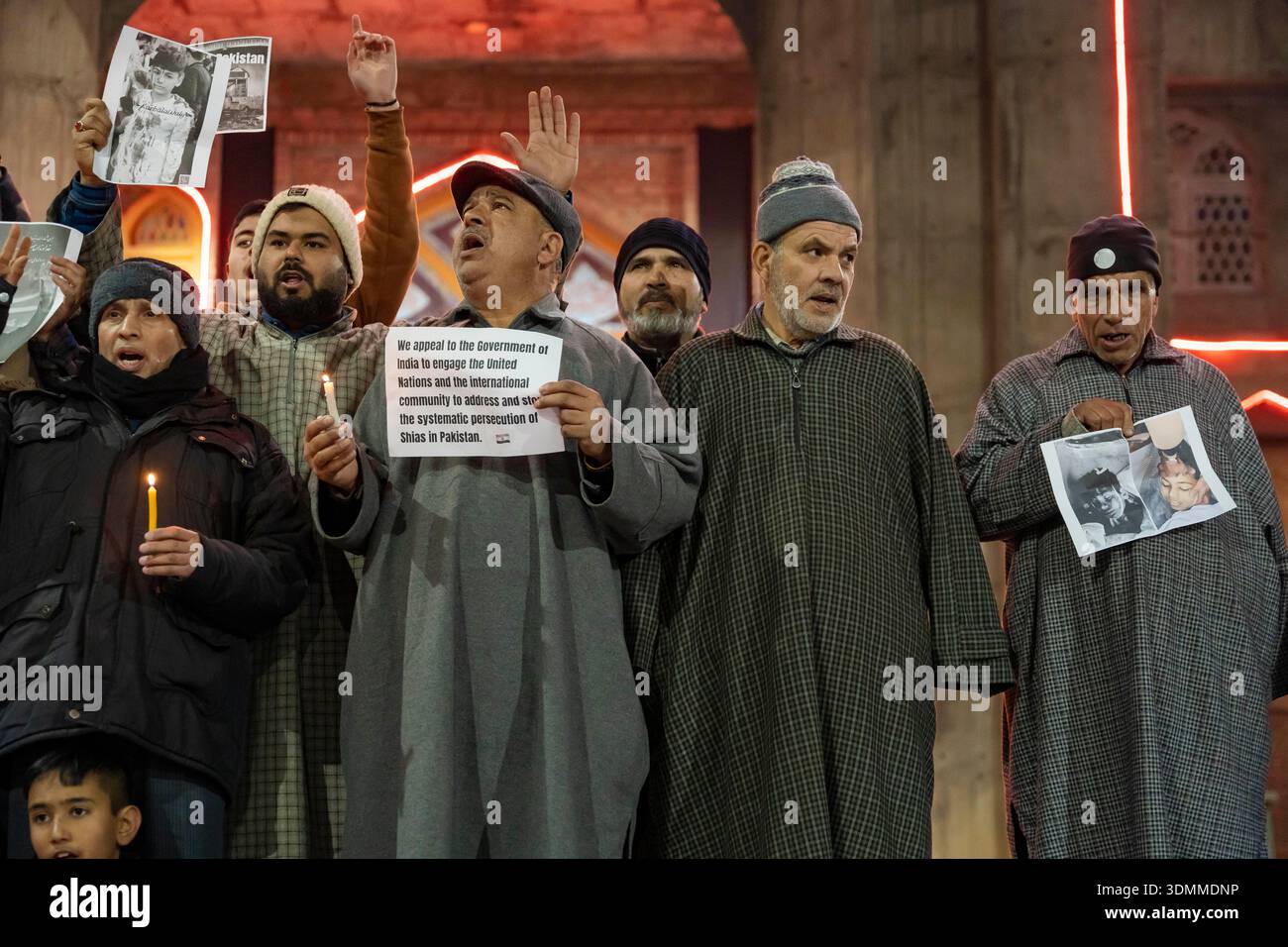 Shia Muslims holding placards and candles shout slogans during a ...