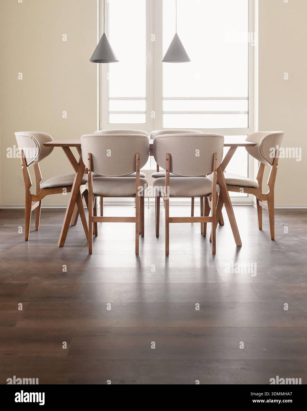 Modern dining room set against a bright, large window. Stock Photo