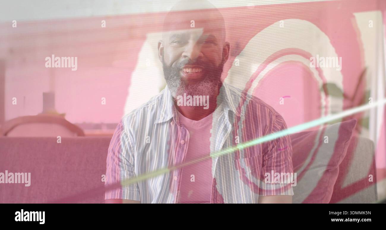 Sitting man wearing striped shirt over white tee on sofa at home, pink overlay casting rings Stock Photo