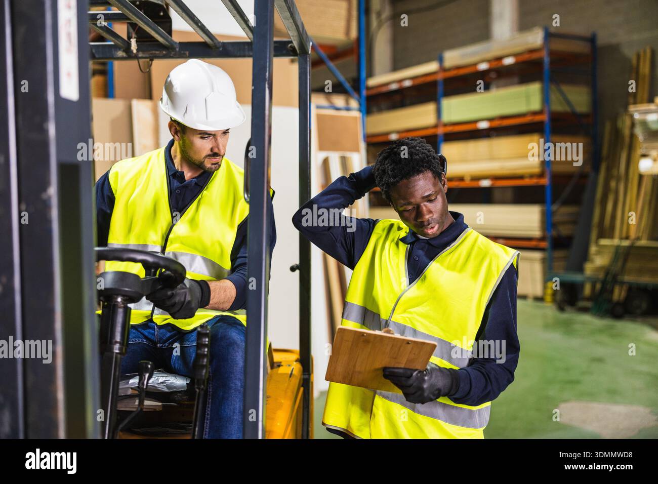 Warehouse workers collaborating on logistics in lumberyard Stock Photo