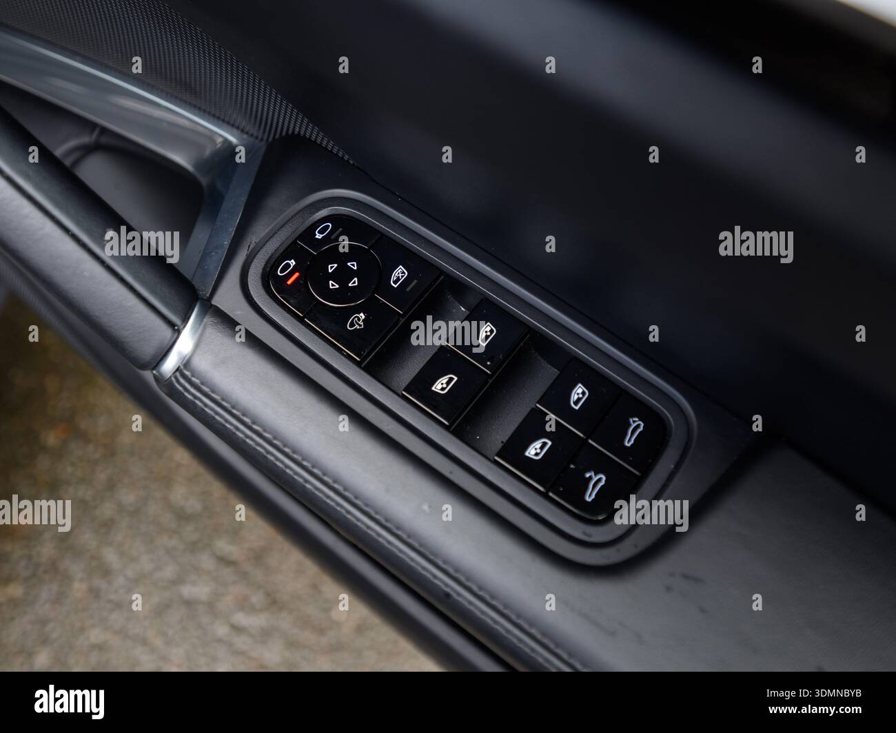 Close-up of car door window controls and mirror adjustment buttons Stock Photo