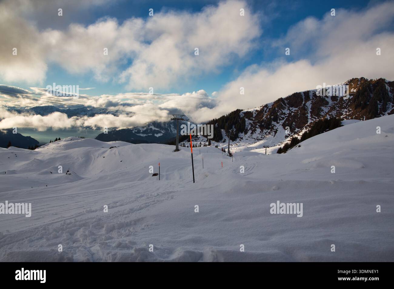 Scenic winter landscape featuring snow-covered mountains and clouds. Stock Photo