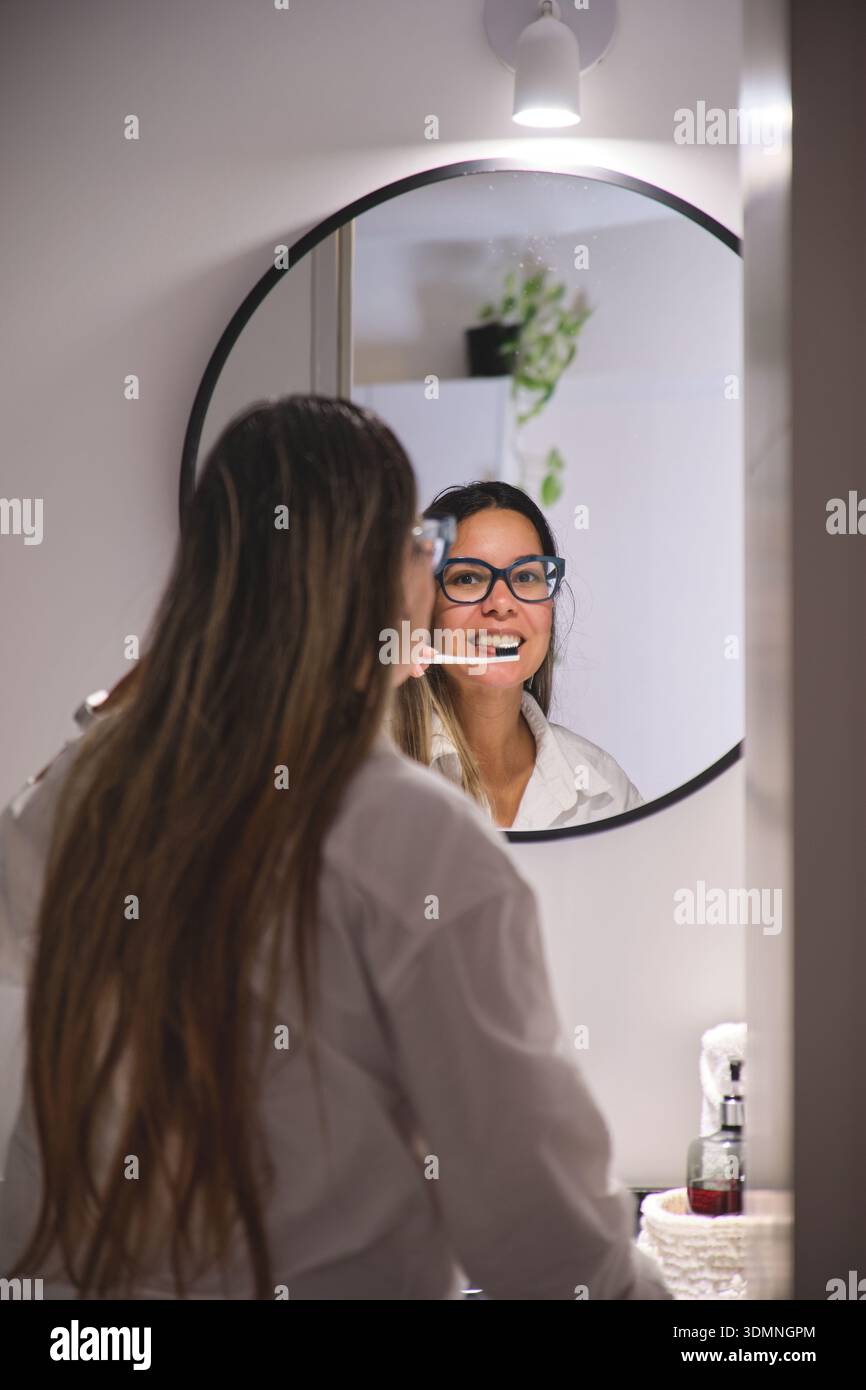 Morning Routine Glasses Woman in glasses brushing teeth in her bathroom morning routine Stock ...