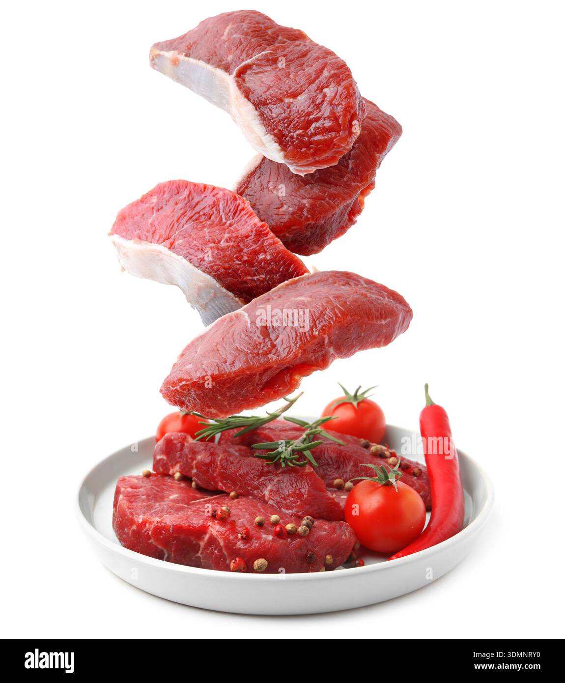 Fresh beef steaks falling on white background Stock Photo