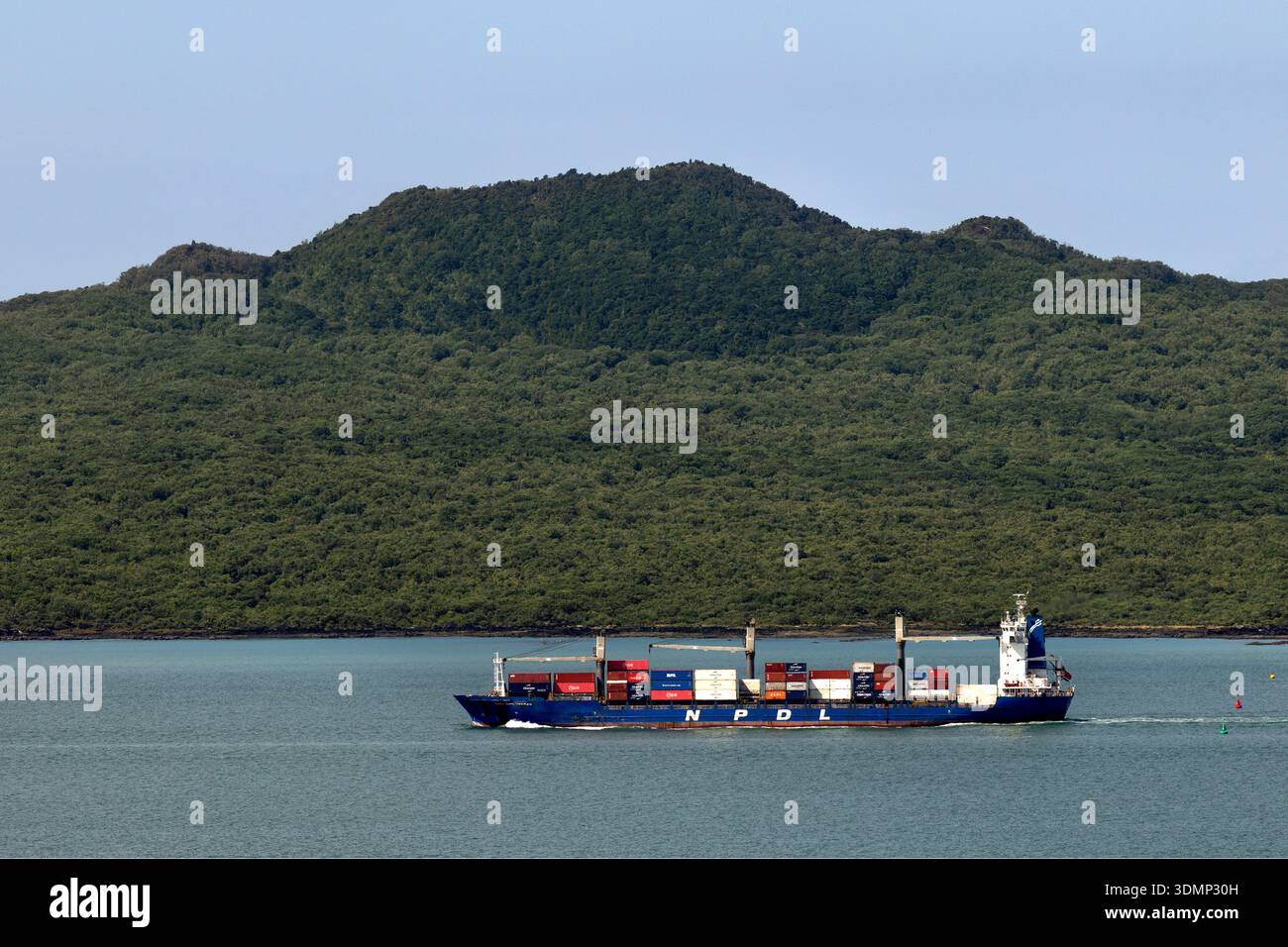 Container ship transits Auckland Harbour with Rangitoto Island in the ...