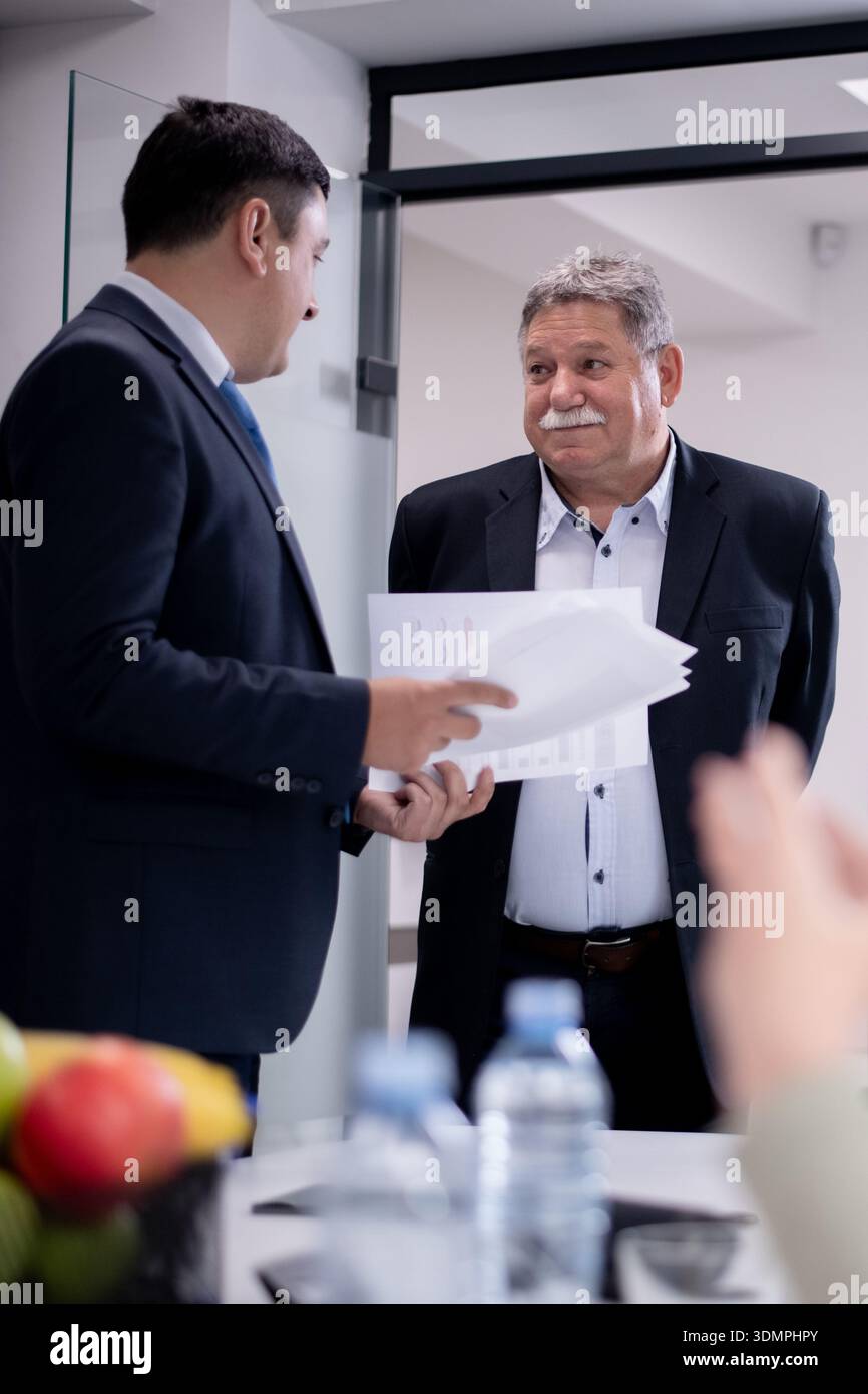 Professional conversation between two colleagues in a modern office environment Stock Photo