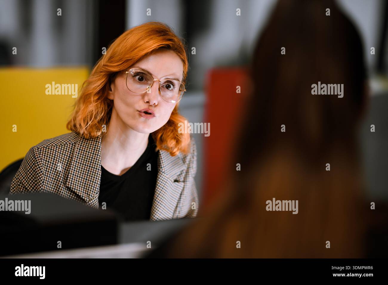 Engaging conversation between two professionals in a modern office setting during the day Stock Photo