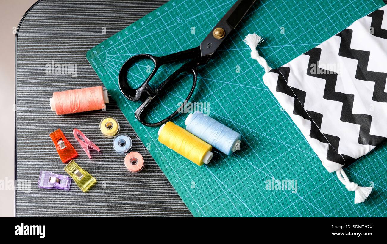 Sewing kit flat lay with fabric clips, bobbins, and pouch Stock Photo