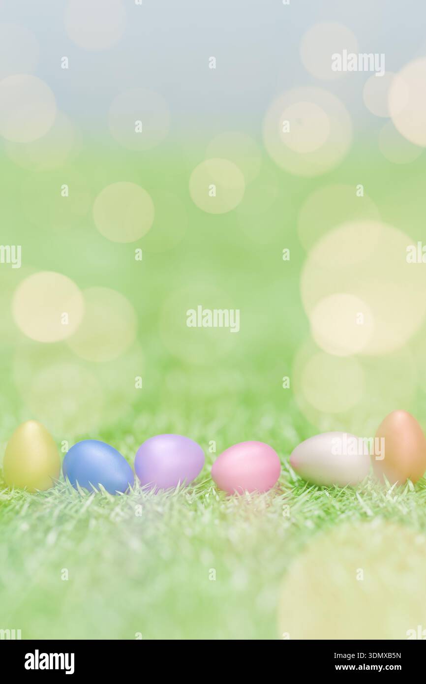 Pastel Easter eggs lined up on green grass with bright, dreamy bokeh lighting effects. 3d rendering Stock Photo
