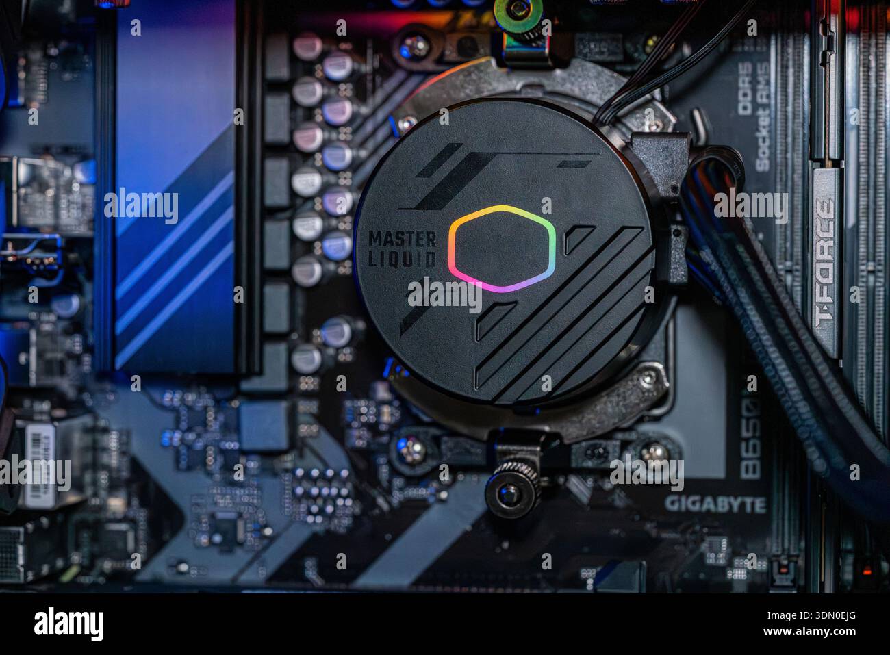 Gaming PC motherboard with RGB liquid cooling pump installed on processor inside modern high performance desktop computer technology Stock Photo