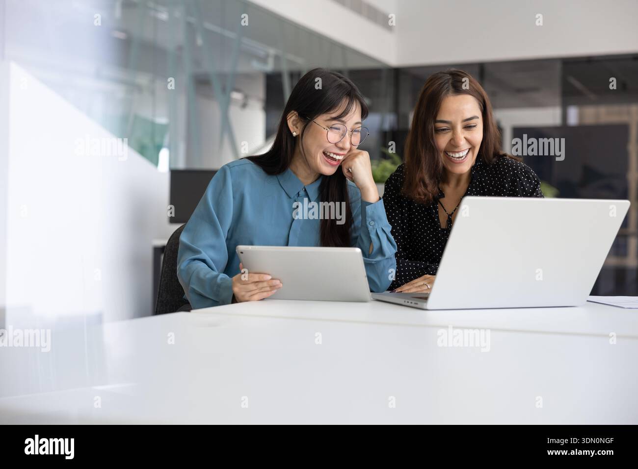 Two cheerful young multiethnic professional having fun and working together Stock Photo