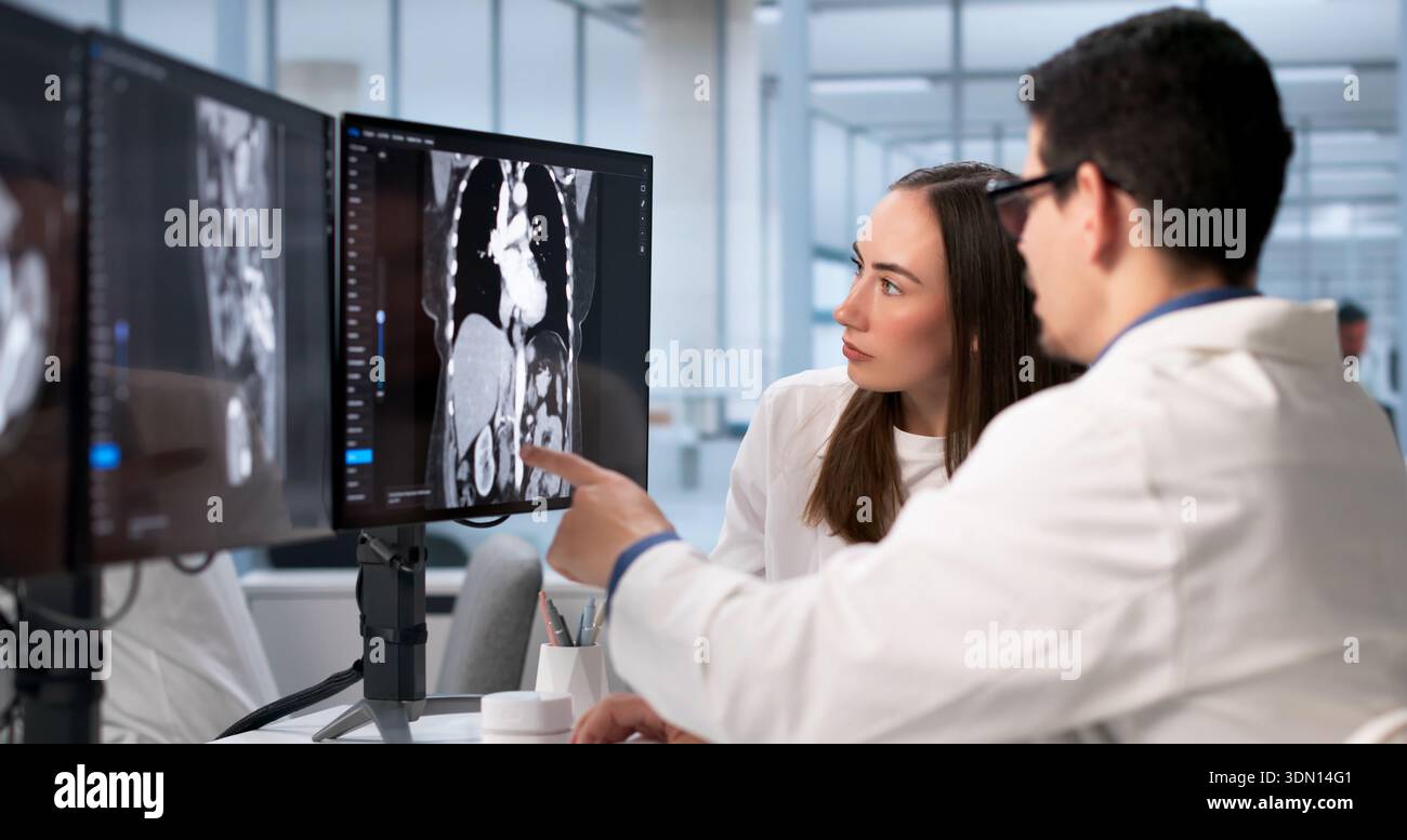 Surgeon And Technician Examine X-ray Of Patient's Fractured Bone. Stock Photo