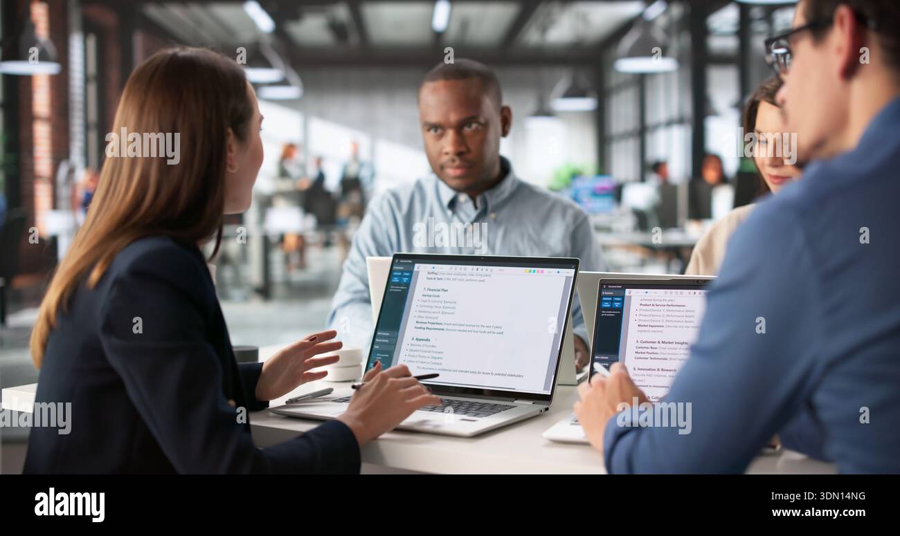 Focused Team Meeting Analyzing Business Plan With Diverse Group Stock Photo