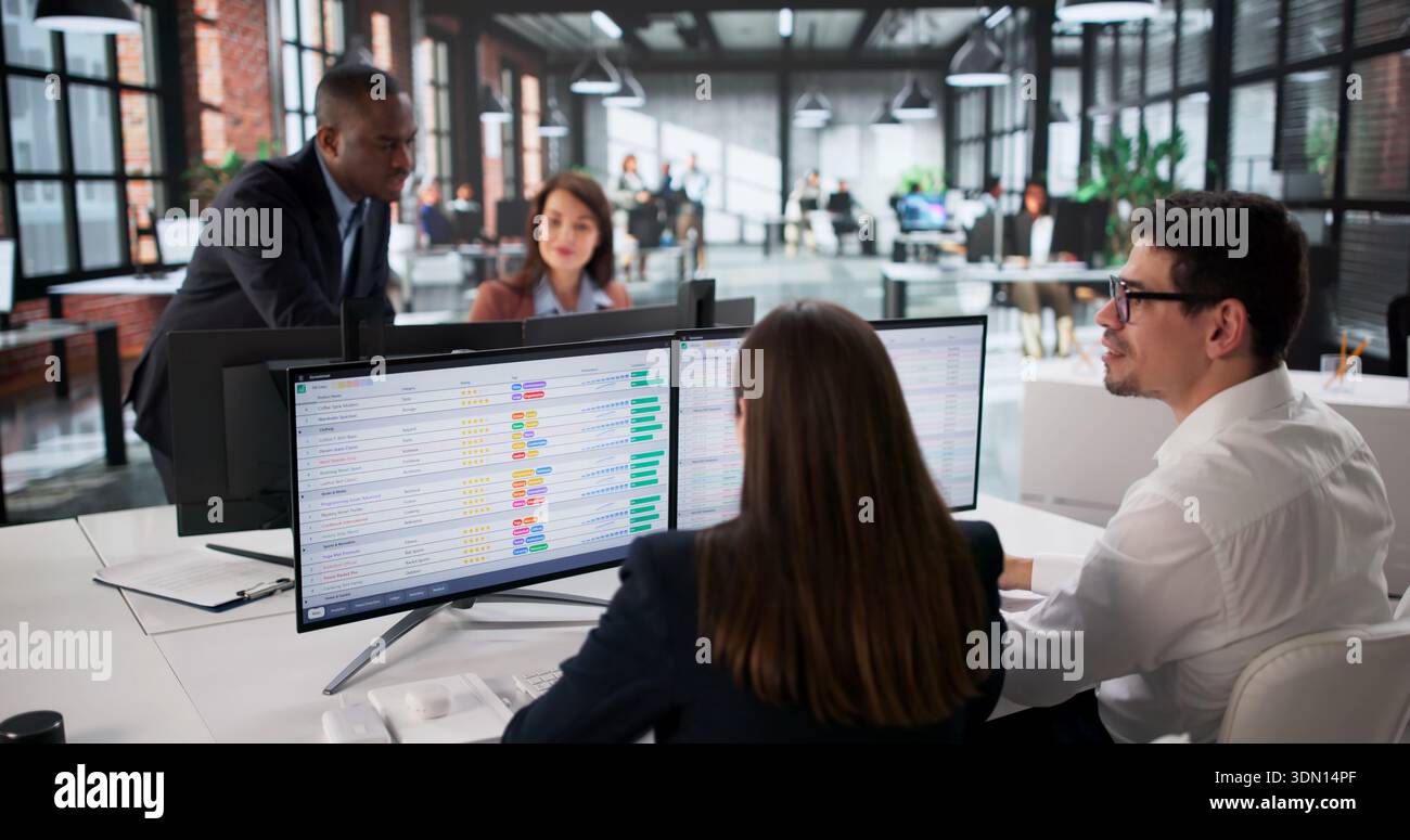 Diverse Business Team Analyzing Data On Computer Screen In Office. Stock Photo