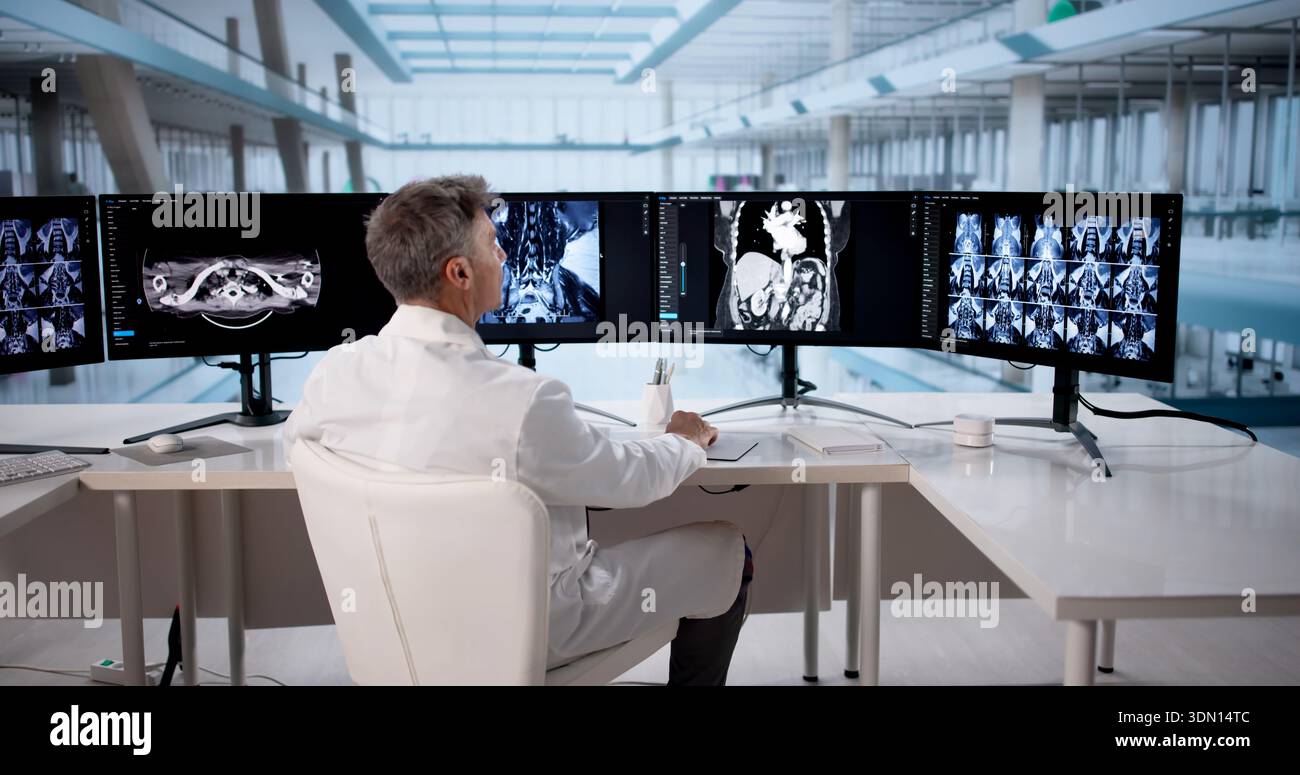 Surgeon Using A Computer Experience Surgeon Analyzing MRI Scans On Desktop Computer Before ...