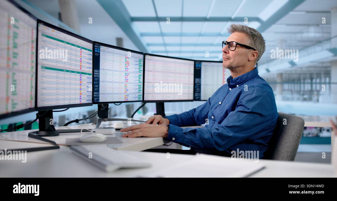 Skilled Office Manager Analyzing Data Across Multiple Business Monitors Stock Photo