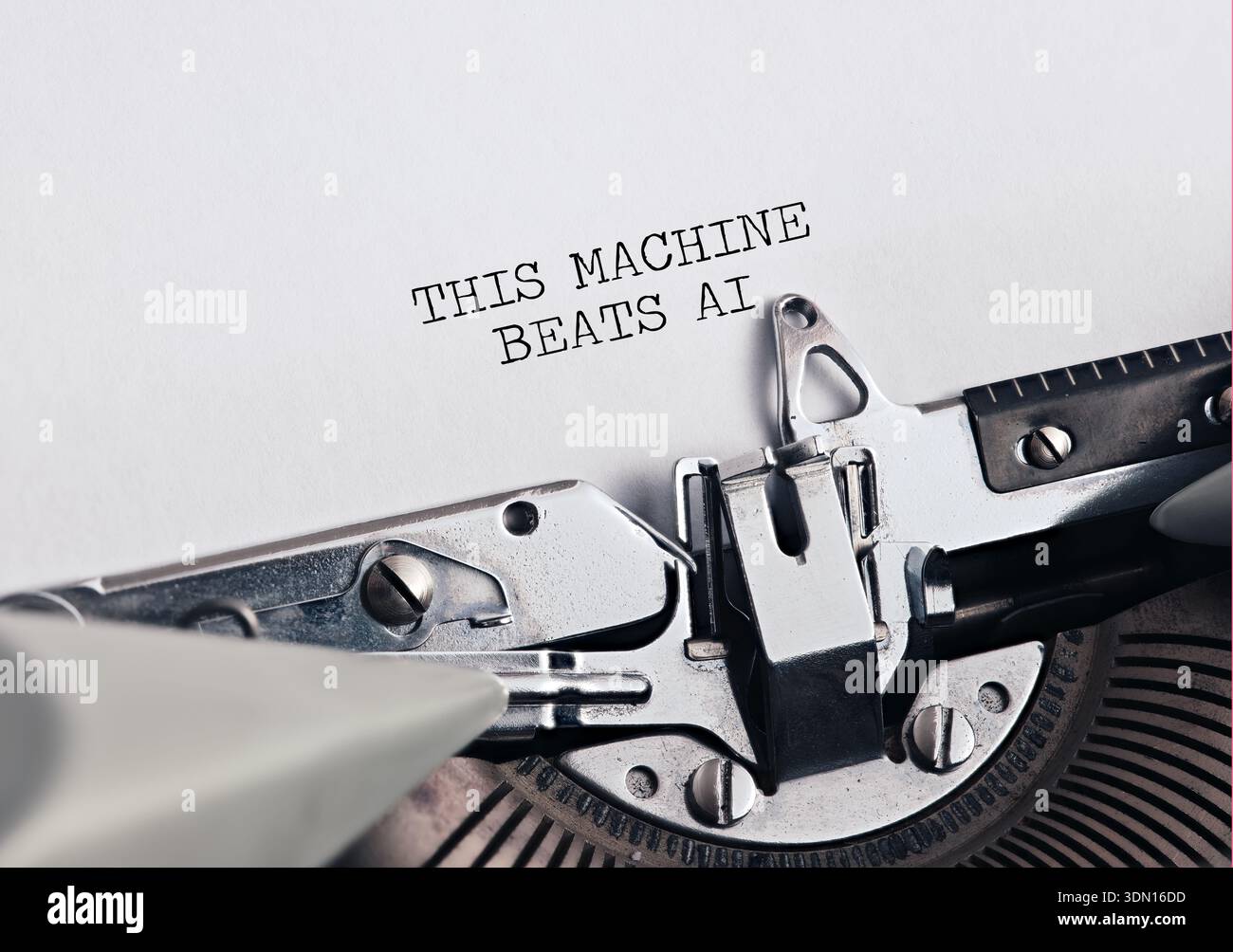 Typewriter typing THIS MACHINE BEATS AI on paper, symbolizing human creativity versus artificial intelligence or tradition versus progress. Stock Photo