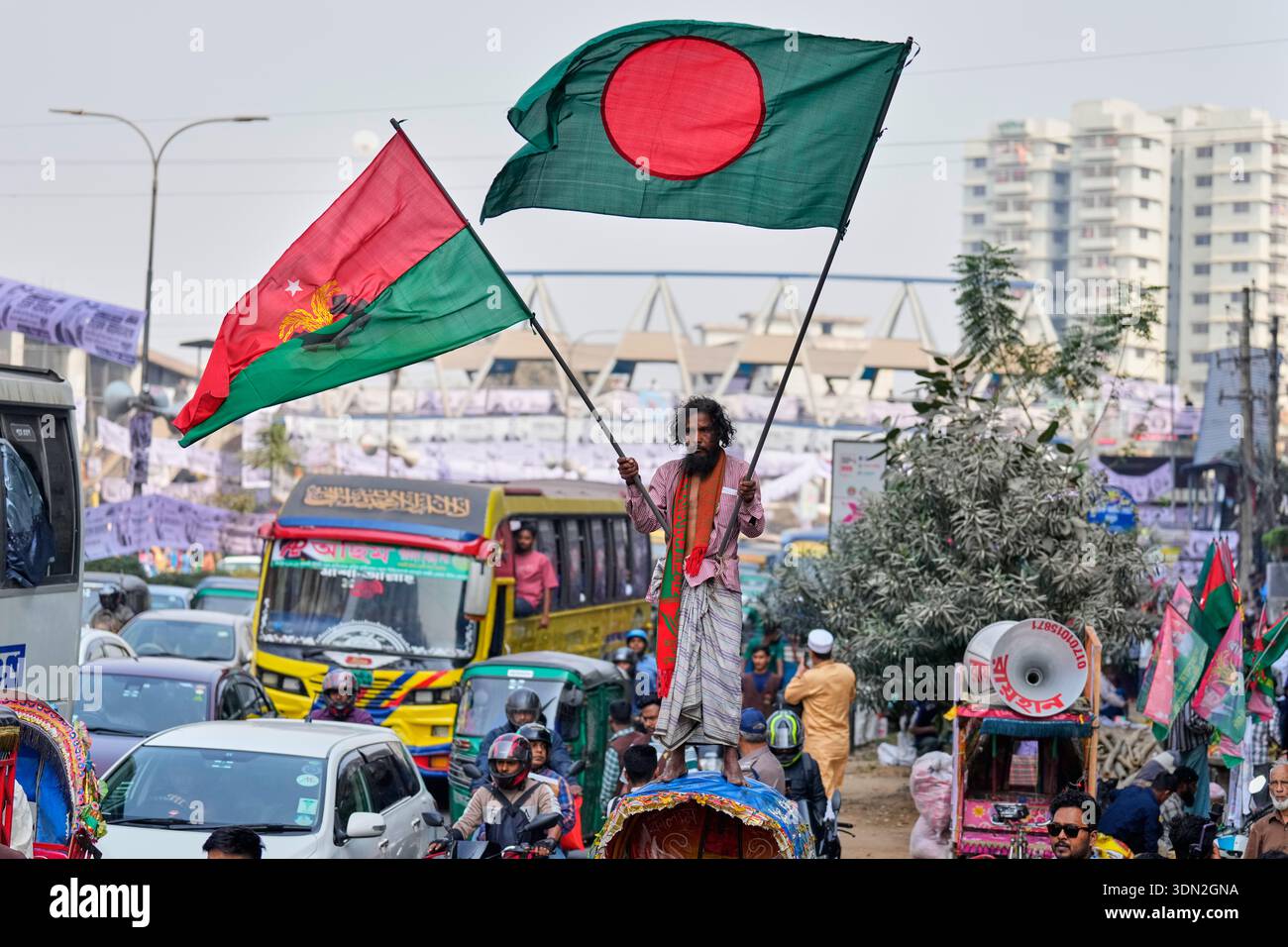 A supporter stands on a rickshaw as he holds a national flag of ...
