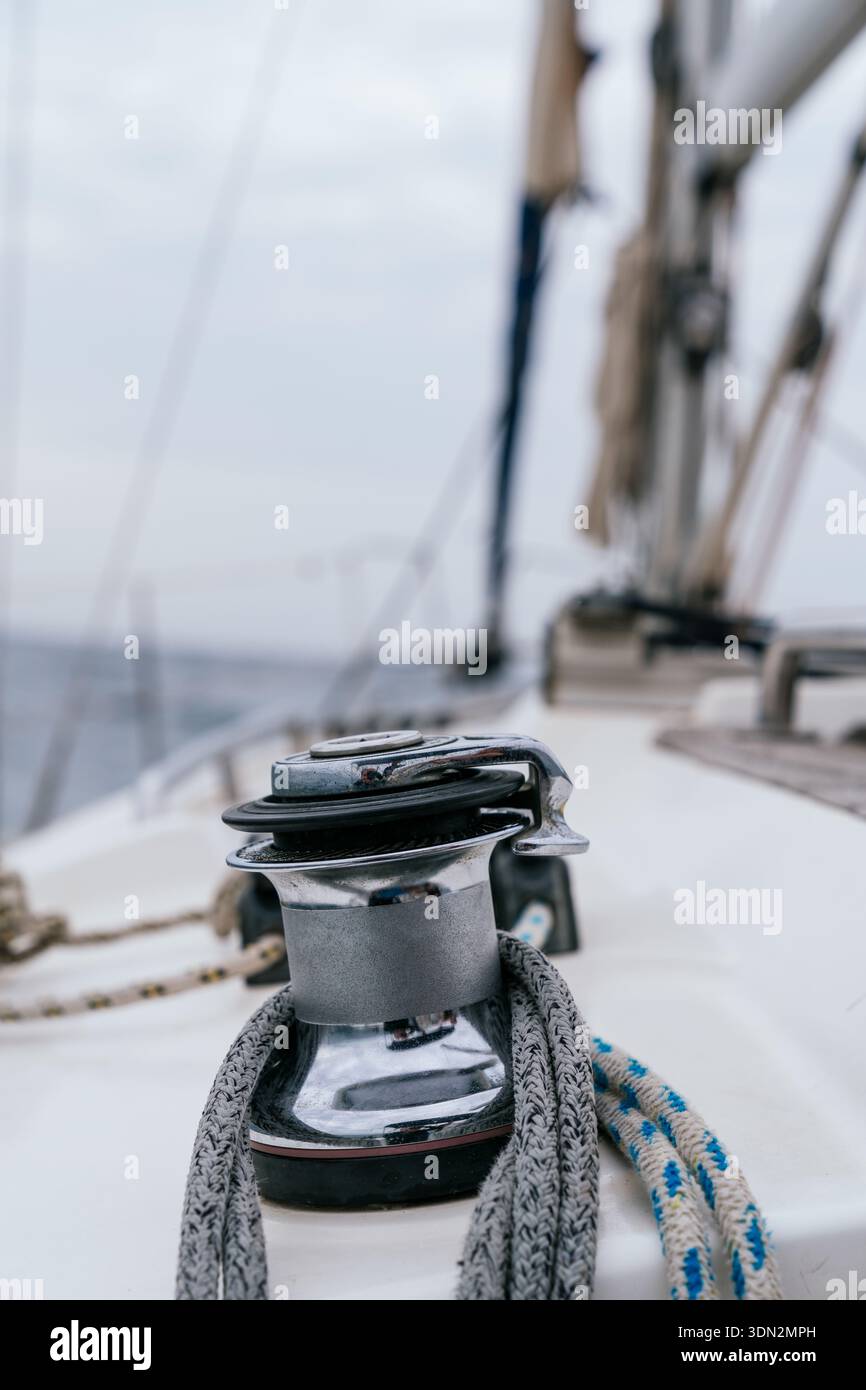 Sailboat winch and rope on deck navigating ocean Stock Photo
