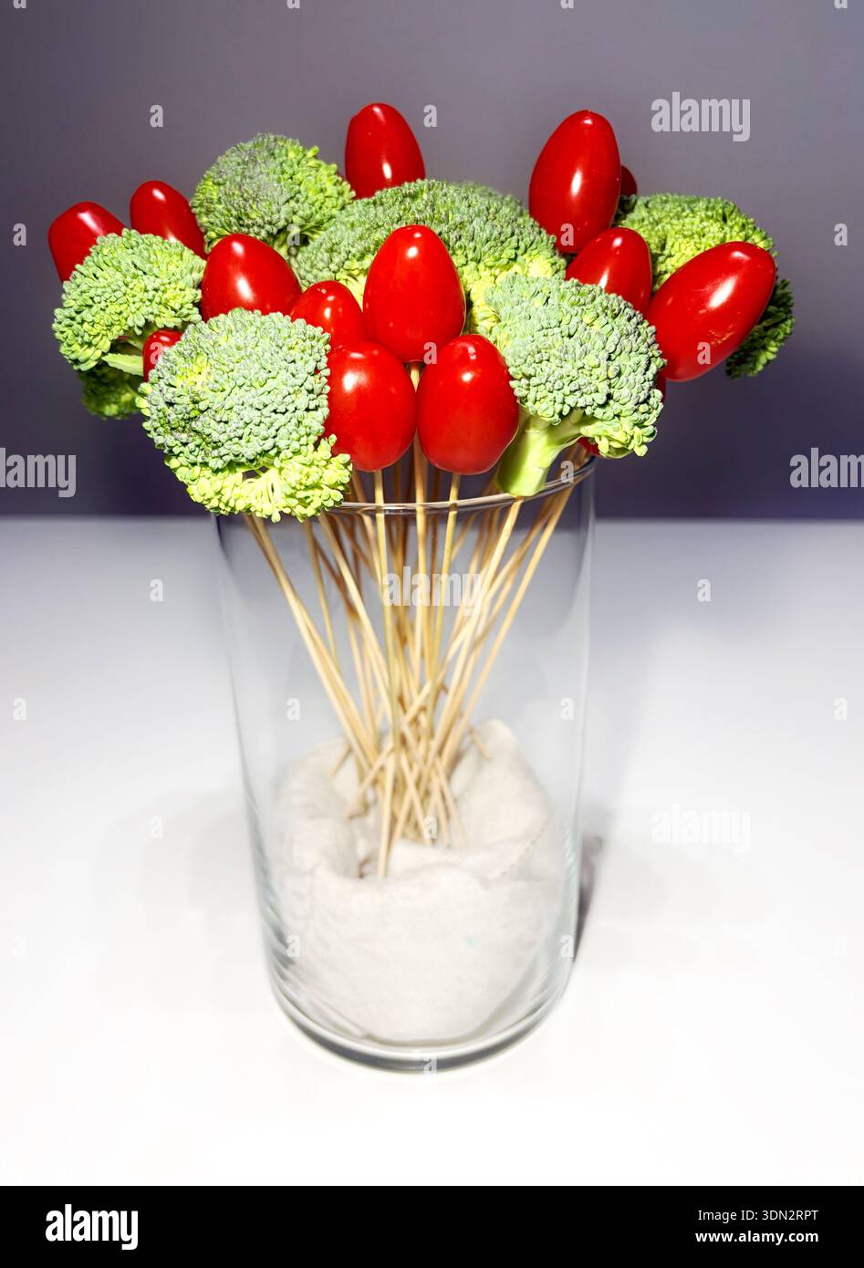 Creative vegetable bouquet with fresh broccoli and cherry tomatoes on wooden skewers in a glass vase. Vegan food and healthy lifestyle concept. - Smartphone Captured Stock Image