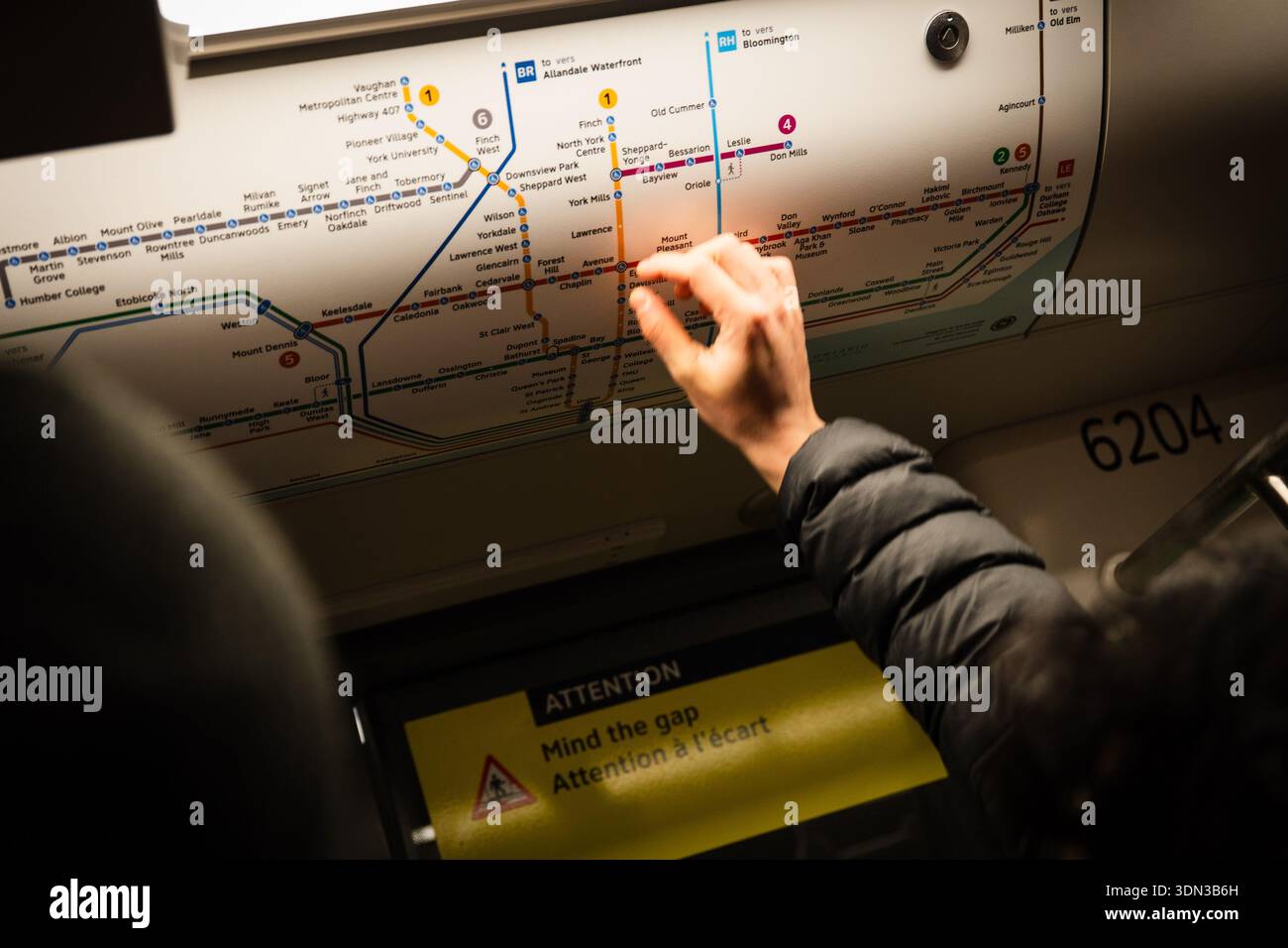 Passengers point at the map while riding the Eglinton Crosstown LRT on ...