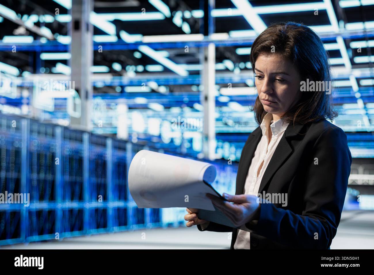 Data center admin reviewing infrastructure checkup technical paperwork ...