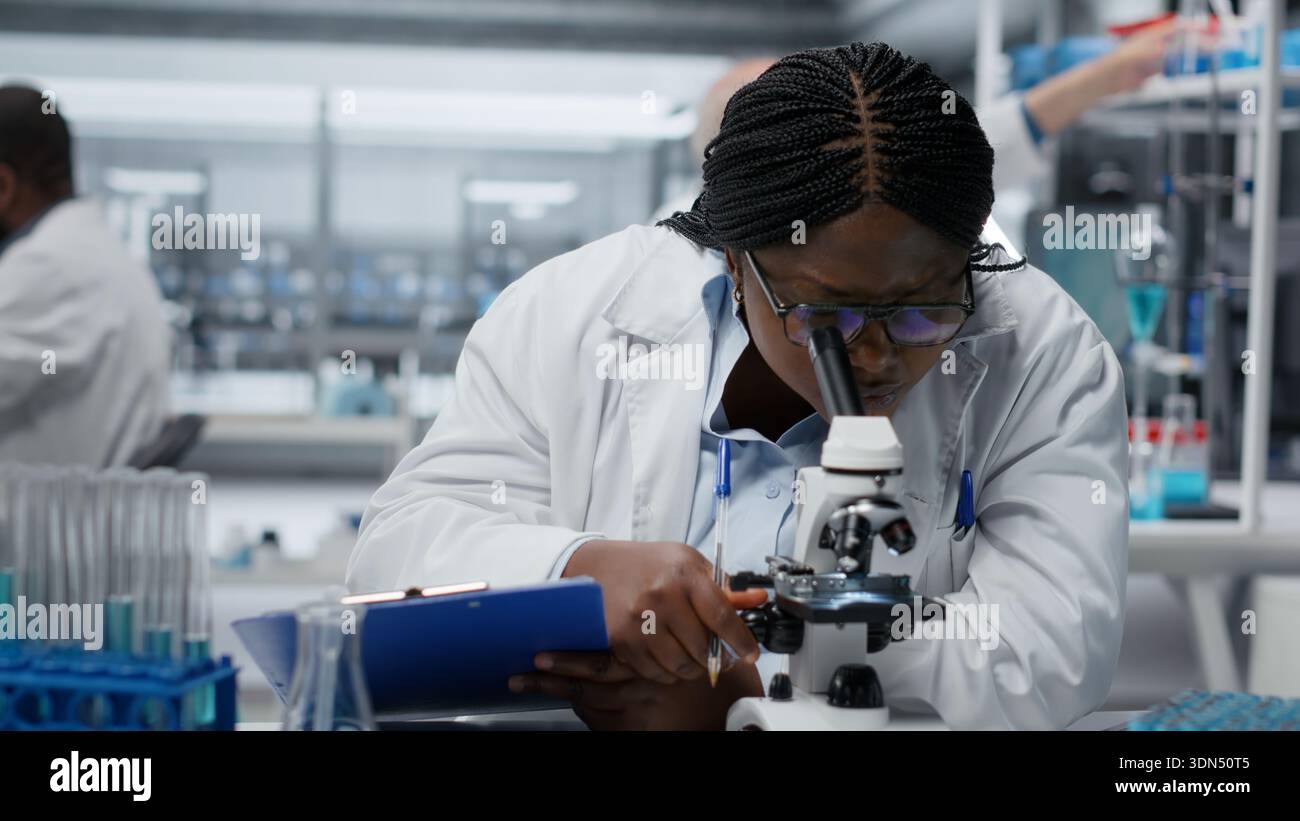 Someone Using Optical Microscope Female scientist using optical microscope to study microorganisms in ...