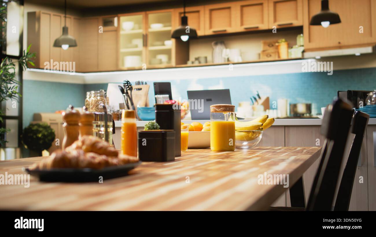 Rustic kitchen with modern furniture and elegant stylish decorations. Home interior features a countertop with organic produce, utensils and cooking essentials. Luxury comfortable living. Stock Photo