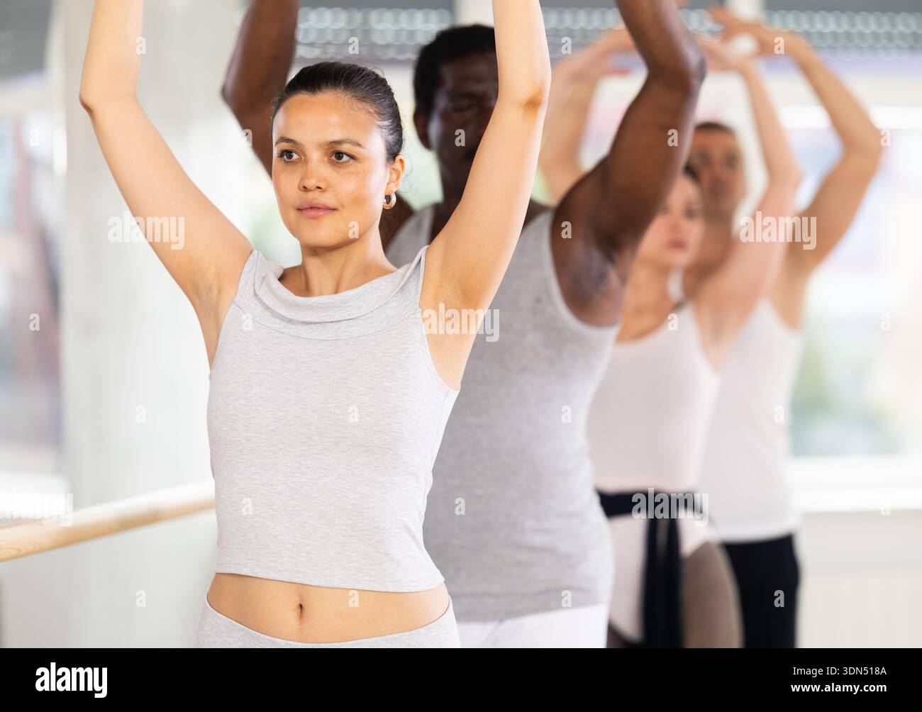 Asian female ballet dancer executing fifth position during group ...