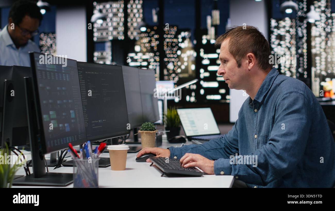 Programmer typing complex code on computer, developing machine learning models to automate business tasks in workspace. Developer writing programming language scripts on PC Stock Photo